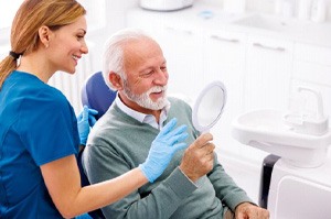 Happy older man talking with dental team member
