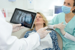 Dentist discussing finding from X-Ray with female patient
