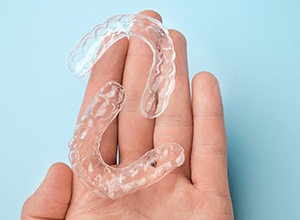 Two clear aligners resting on person’s hand