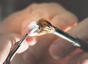 Close-up of hands working to create ceramic dental crown