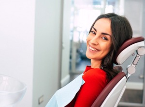 Female patient smiling after receiving ceramic dental crown