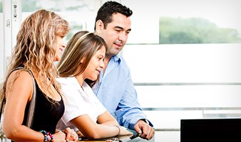 Family of three checking in at dental office reception desk