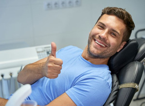 Dental patient making thumbs-up gesture