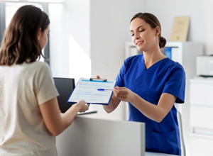 Dental team member handing clipboard to patient