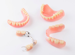 Full and partial dentures against white background