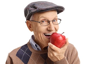 senior man eating apple