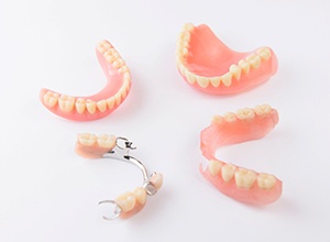 Partial and full dentures arranged against neutral background
