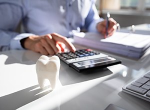 Man using calculator to budget for dental care