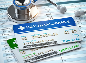 Cards for dental and medical insurance next to stethoscope
