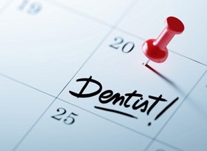 Dental appointment marked on calendar with red push pin