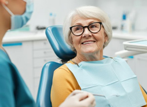 Happy senior patient interacting with dental team member