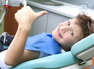 Young boy smiling and giving thumbs up