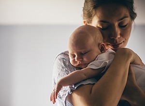 Mother holding sleeping baby