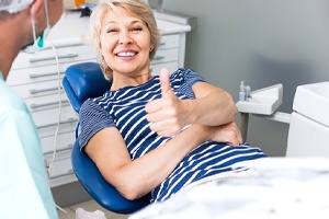 Patient giving thumbs up for successful tooth extraction