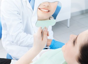 Patient using mirror to view results of her cosmetic treatment