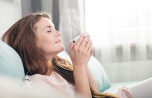 Woman with Invisalign in Abington enjoying a cup of coffee