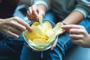 Friends sharing a bowl of salty chips