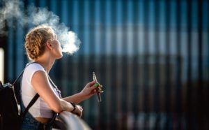 Woman standing outside, using e-cigarette