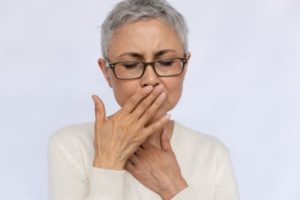 Senior woman embarrassed by bad breath