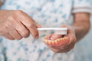 Senior person cleaning their denture